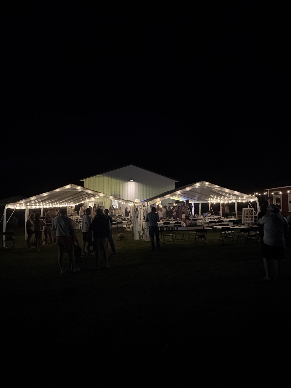 Event tents illuminated with lights at an evening gathering