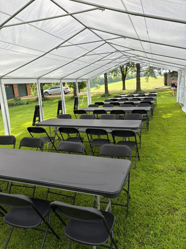 Rows of chairs and tables under an event tent