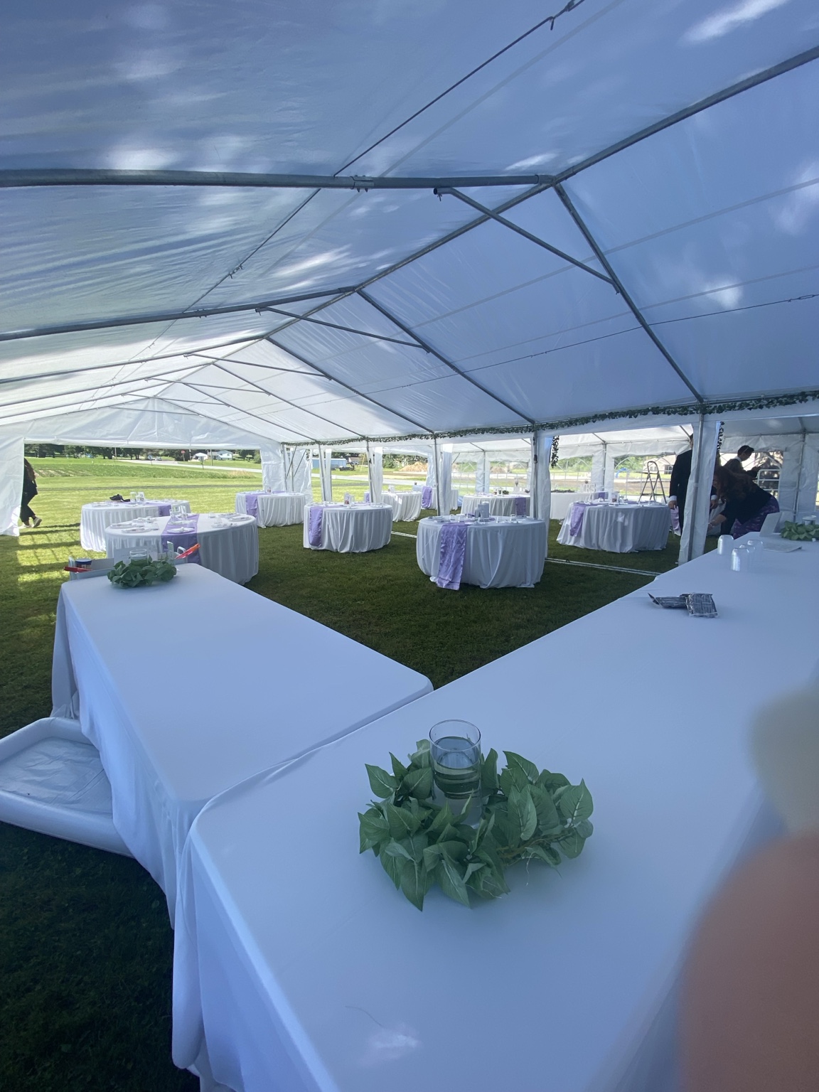 Tables arranged for an event under a white tent