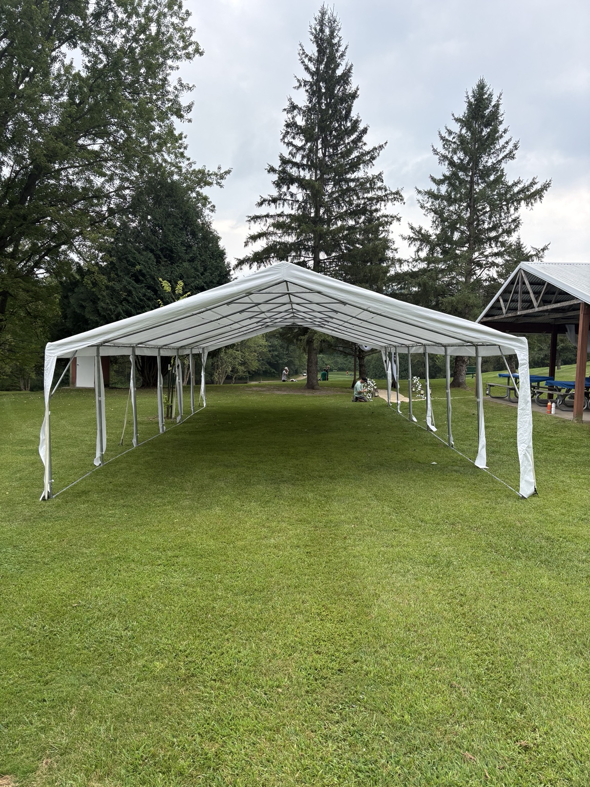 White frame tent set up on grass