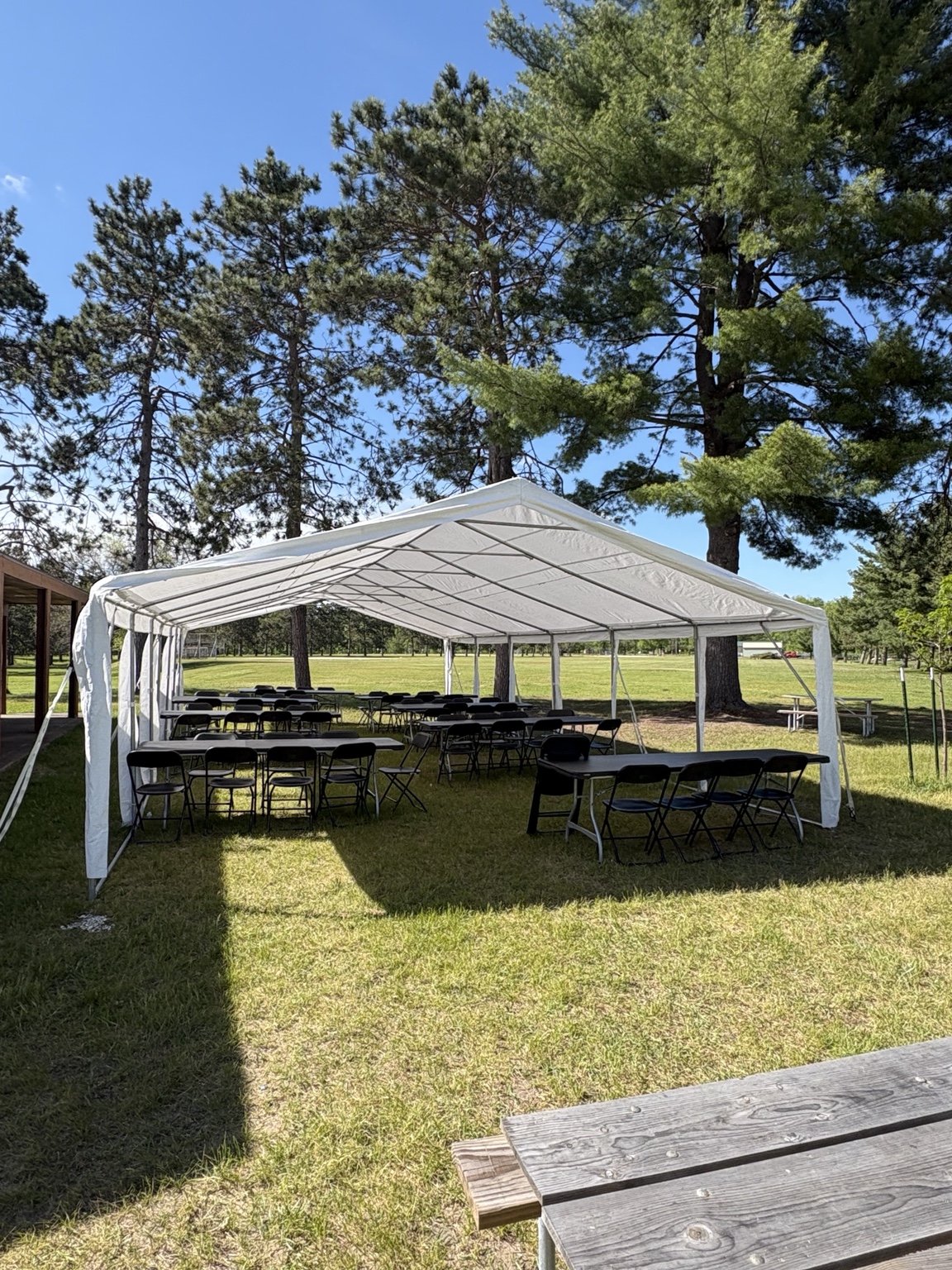 Tent with tables and chairs in a park